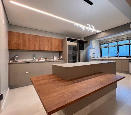 Cozinha Planejada Cinza Beton com Ilha e bancada no amadeirado Solanum Instalada em São Vicente