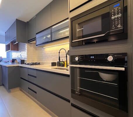 Cozinha Planejada Grafite MDF Manhatan e portas de vidro reflecta prata com iluminação em LED instalada pela DECORATA em Santos