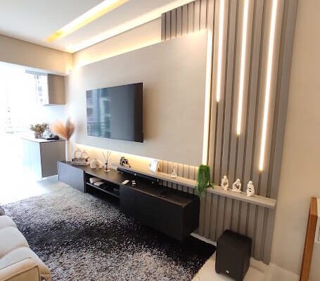 Painel de TV com ripado cinza e rack preto com iluminação em LED instalado pela DECORATA em Santos