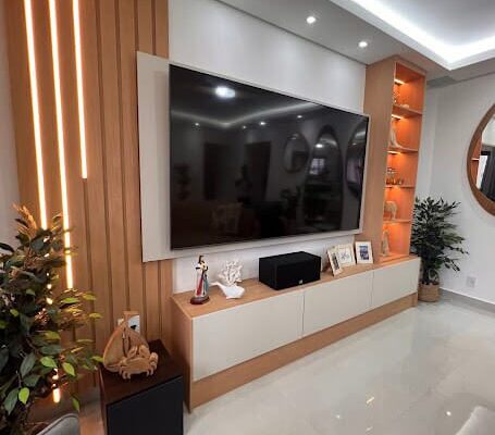 Painel de TV com ripado amadeirado iluminação em cascata e iluminação nos nichos decorativos instalado pela DECORATA em Praia Grande SP