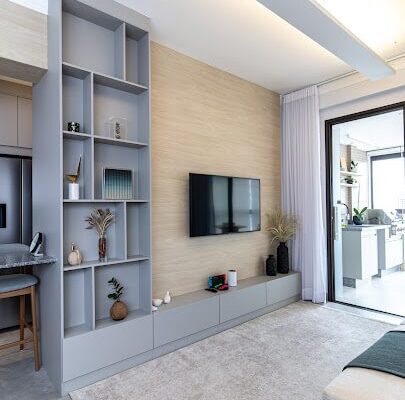 Painel de TV com nichos Beton e painel amadeirado Veredas, rack com puxadores passantes instalado pela DECORATA no Canto do Forte em Praia Grande